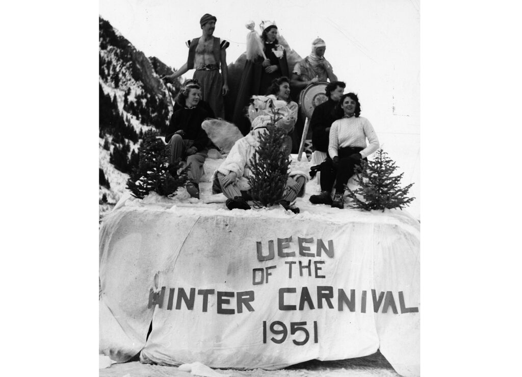 One mounted b/w photograph of the first Winterskol parade, showing the Winterskol Queen and runners-up on a float that says "Queen of the Winter Carnival 1951" (the "Q" is missing from the float). Elli Whitten (aka Elli Spence and Gale Spence) was the winner. Others identified are Sally Baker, Joan Wilson (hidden), Dave Darling, Helen Leatherbury, Bete Woods, Loyette Gamba, and Bob Marsh (behind tree).