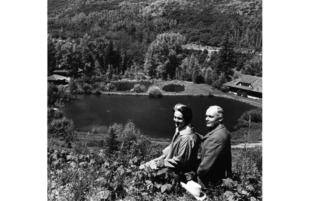 One b/w photograph of Robert O. Anderson and his wife Barbara Anderson seated on the hill above the music school campus taken July 11, 1965. Taken the day which the Aspen Institute (of which Robert O. Anderson was a chairman of the board for) gave the land and buildings up Castle Creek to the Aspen Music School and festival (also known as the Music Associates of Aspen - MAA) The facilities had formerly been the Four Seasons Resort and the Newman Mine.