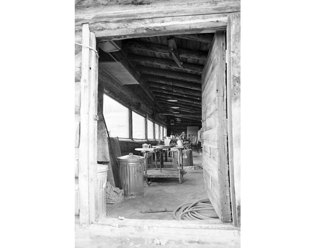 One b/w negative of the interior of the ceramics studio with pottery wheels lined up in front of the windows at Anderson Ranch at Snowmass, 1967.