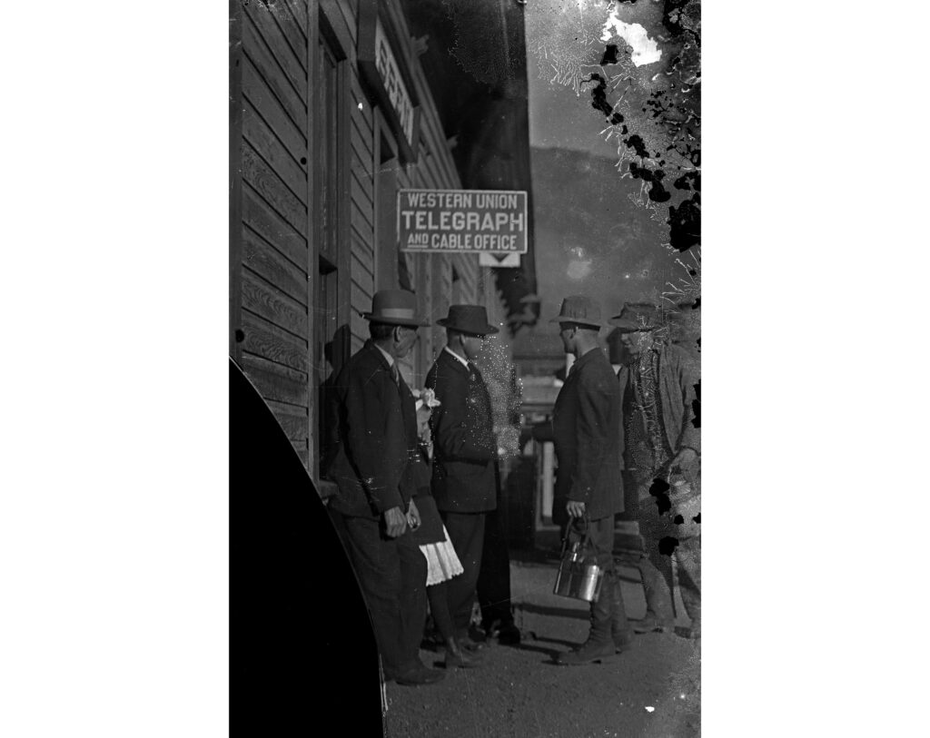 One glass-plate negative of the Colorado Midland depot and telegraph station, with some men standing just below the sign which reads "Western Union Telegraph and cable office"