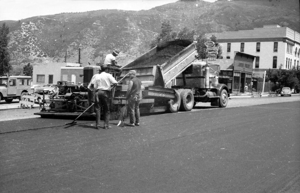 One b/w 35mm negative of paving operations on Main Street, 1963. This image is in the Aspen Flyer on August 24, 1963, with a caption reading "The largest municipal construction project in recent years will mean the end of chuck holes in downtown-area streets by early fall. Members of Grand Junction's Corn Construction Co. are shown in action on Main St. several weeks ago." paving