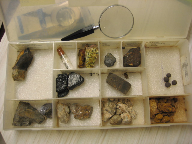 Color image of minerals and mining commonly found in local mines with a magnifying glass and labels for each type of rock.