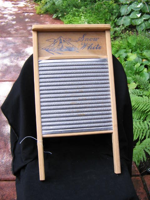 Color image of a Snow White wooden framed tin washboard used for washing and scrubbing clothes before machine washing machines.