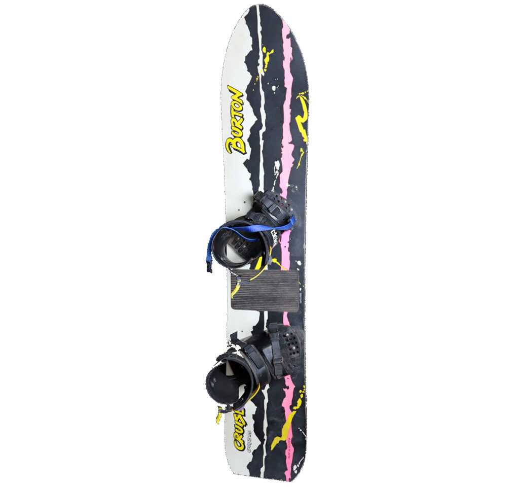 One Burton Cruise snowboard, 1989. It is 165cm long, and has the matching Burton bindings from that same year. Features of this board: • Had a Fiberglass/Urethane core construction • Variable Flex Pattern for easy turns but consistent carves. • Rounded kicked-tail freestyle design for maneuverability and tricks. • All mountain board According to the 1989 Buyer's Guide: "The Burton Cruise 165, as with the 155, is a board all levels of riders can enjoy. It floats softly in powder but can still take the abuse of big air in an icy halfpipe. The size and flex are ideal for riders over 140 pounds or those who are aggressive on the edge, but the board will accommodate all ability levels.”